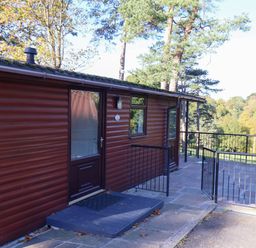 A cabin with a deck and railing at Violet Lodge in Saltburn-by-the-Sea