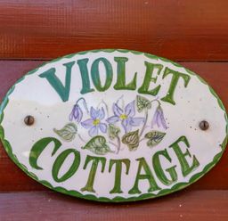 A sign reading Violet Cottage with floral design at Violet Lodge in Saltburn-by-the-Sea