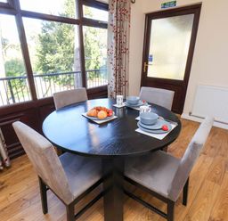 A dining room with a round table and chairs at Violet Lodge in Saltburn-by-the-Sea