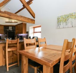 A kitchen with wooden furniture at Yew Tree Cottage in Torver