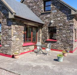 An outdoor setting with a table and chairs at Stone Cottage, Waterville, County Kerry