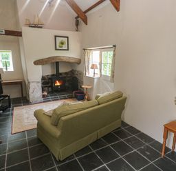 A living room with a sofa and television at Swallows, St Keverne, Lizard Peninsula