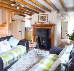 A living room with two leather sofas and a fireplace at Fell View Cottage in Bootle near Millom
