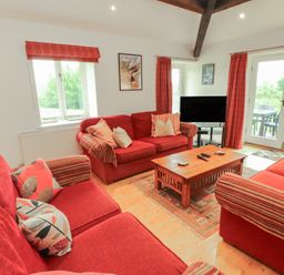 A living room with a sofa and television at Winster Fields in Cartmel Fell near Windermere