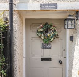 An entryway with a door and wreath at 24 Church Street in Winsham