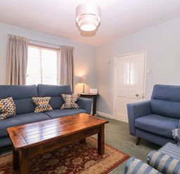 A living room with a sofa and armchair at The Lock House in Gloucester