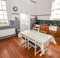 A kitchen with a wooden table and chairs a sink and appliances visible at The Old School House Gortermone near Carrigallen County Leitrim