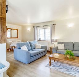 A living room with blue sofas and a wooden coffee table with a plant at Horseshoe in Little Glemham near Wickham Market