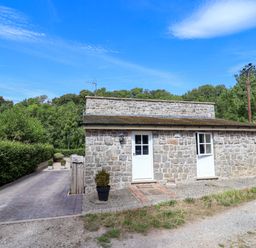 A stone building with doors and windows at The Lambing Shed in Dyserth near Prestatyn