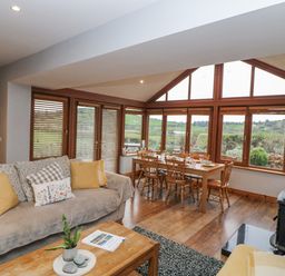 A living room with a dining area at Lough Cluhir Cottage in Union Hall, County Cork