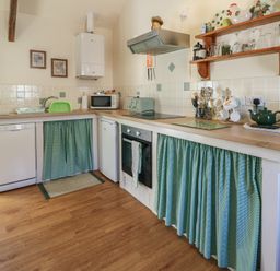 A kitchen with appliances and utensils at Lily Cottage Caeathro near Caernarfon