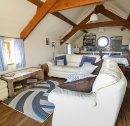 A living room with a sofa and table at Bluebell Cottage in Caeathro near Caernarfon