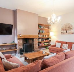 A living room with a television and bookshelf at The Lodge in Snainton near Scarborough