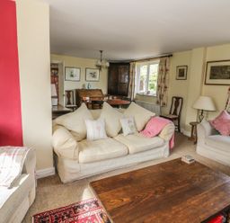 A living room with cream sofas and wooden coffee table at Highcroft in Stratford-Upon-Avon