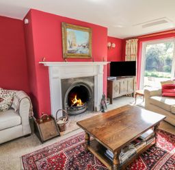 A living room with a fireplace armchairs a wooden coffee table and a television at Highcroft  Stratford-Upon-Avon