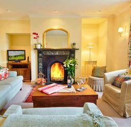 A living room with a fireplace and seating area at The Old Farmhouse in Lowick