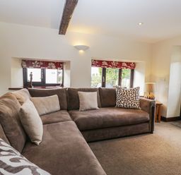A living room with a sofa and windows at Woodside Barn Pennington near Ulverston