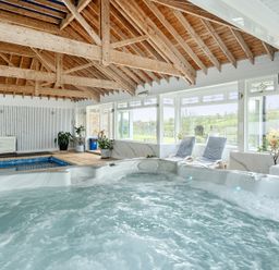 An indoor swimming pool area with a hot tub at Chapel Green in Polgooth