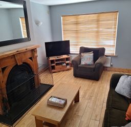 A living room with a fireplace, sofa, and coffee table at 19 River Glen in Curracloe, County Wexford