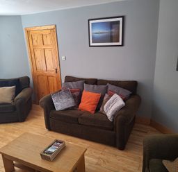 A living room with a sofa and armchairs at 19 River Glen, Curracloe, County Wexford