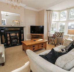 A living room with a fireplace and a television at Tyddyn Goronwy in Talybont
