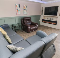 A living room with a sofa and a recliner at Meadow View in Laugharne