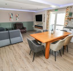 A living room with a sofa and dining area at Meadow View in Laugharne