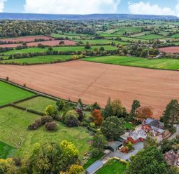 An aerial view of fields and a house with trees at The Croft in Vowchurch near Peterchurch
