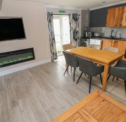A kitchen with a dining table and appliances at Dylan's Court in Laugharne