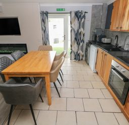 A kitchen with a dining table and modern appliances at Dylan's Court in Laugharne