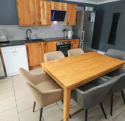 A kitchen with a dining table and appliances at Dylan's Court in Laugharne