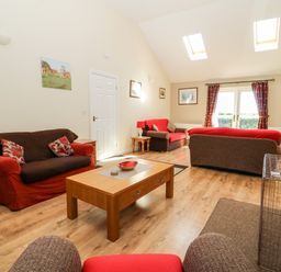 A living room with sofas and a wooden coffee table under skylights at 2 Pines Farm Cottages in Ulleskelf