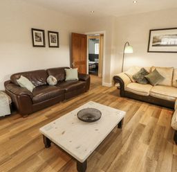 A living room with a brown sofa and coffee table at White Gables Great Clifton near Cockermouth