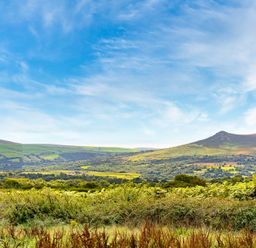 A landscape with hills and fields under a blue sky at Bwthyn Bach in Newport