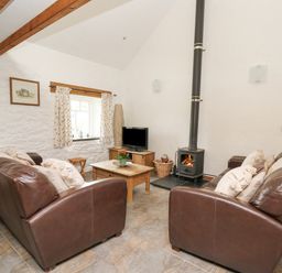 A living room with a fireplace and sofa at Bwthyn Bach in Newport