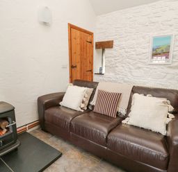 A living room with a sofa and a fireplace at Bwthyn Bach in Newport