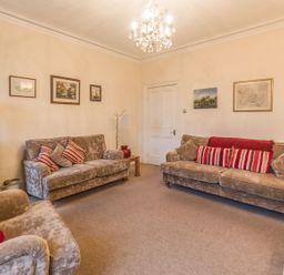 A living room with three sofas and framed pictures on the walls at The Old Exchange in Corbridge near Hexham
