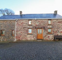 A house with stone walls and a front door at Bwthyn Trecoed St. Clears near Carmarthen