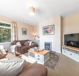 A living room with brown sofas a wooden coffee table and a television at Colt Park Cottage in Ulverston