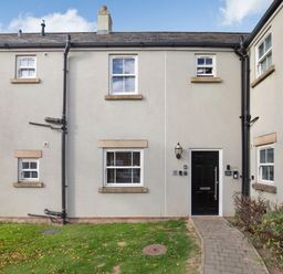 The front exterior of a house with a black door and white framed windows at Perriwinkle The Bay near Filey