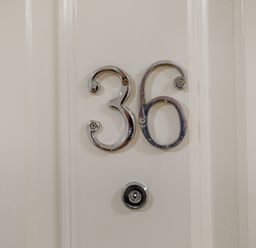 A white door with metallic number 36 and a doorbell at Perriwinkle The Bay near Filey