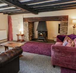 A living room with a fireplace and furniture at Penlone Cottage in Rhayader