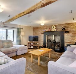 A living room with sofas a coffee table a television and a fireplace at The Birches in Hay-on-Wye