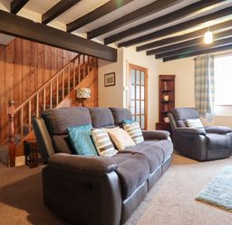 A living room with sofas and a staircase at Bryn Re Trawsfynydd near Llan Ffestiniog and Dolgellau