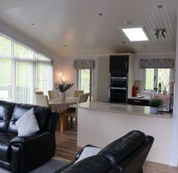 A living room with a kitchen island and seating area at High View Lodge White Cross Bay near Troutbeck Bridge