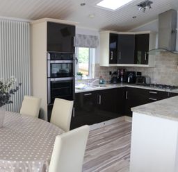 A kitchen with an oven, sink, and table at High View Lodge near Troutbeck Bridge