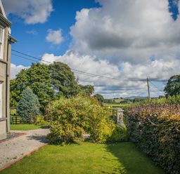 A garden with plants and trees at The Farm House in Bala