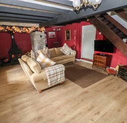 A living room with a sofa and a stove at Maesgwyn in Bridell near Cardigan
