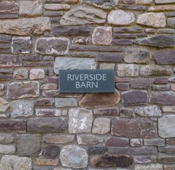 A sign on a stone wall at Riverside Barn in Gilwern near Crickhowell and Abergavenny
