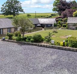 An outdoor area with buildings and garden features at New Barn in Winterborne Stickland